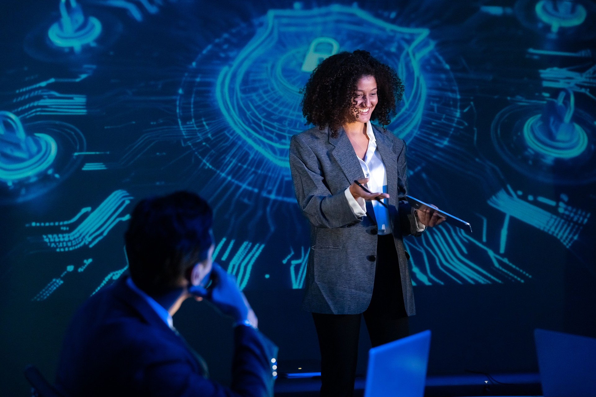 Confident female speaker presenting on global technology and cybersecurity at a seminar or conference.